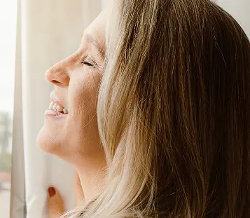 Mulher sorrindo durante momento de autocuidado